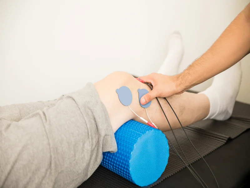closeup-physiotherapist-s-hand-positioning-electrodes-patient-s-knee-hospital